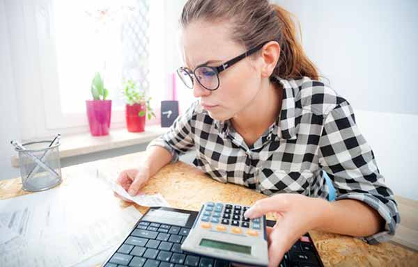 Average Cost of Utilities for a House | Photo of Woman Paying Bills