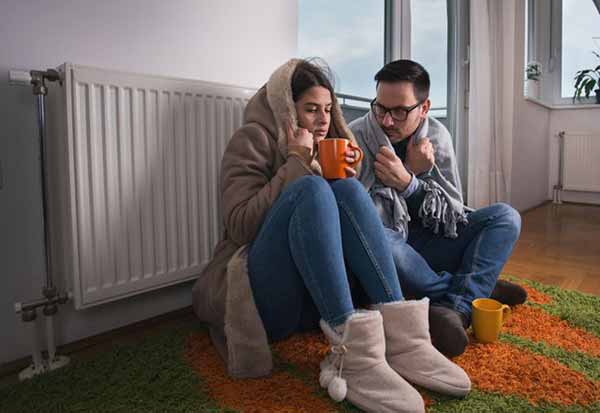 UK Energy Bills Effect | Couple in Front of Heater UK Energy Bills Effect | Couple in Front of Heater