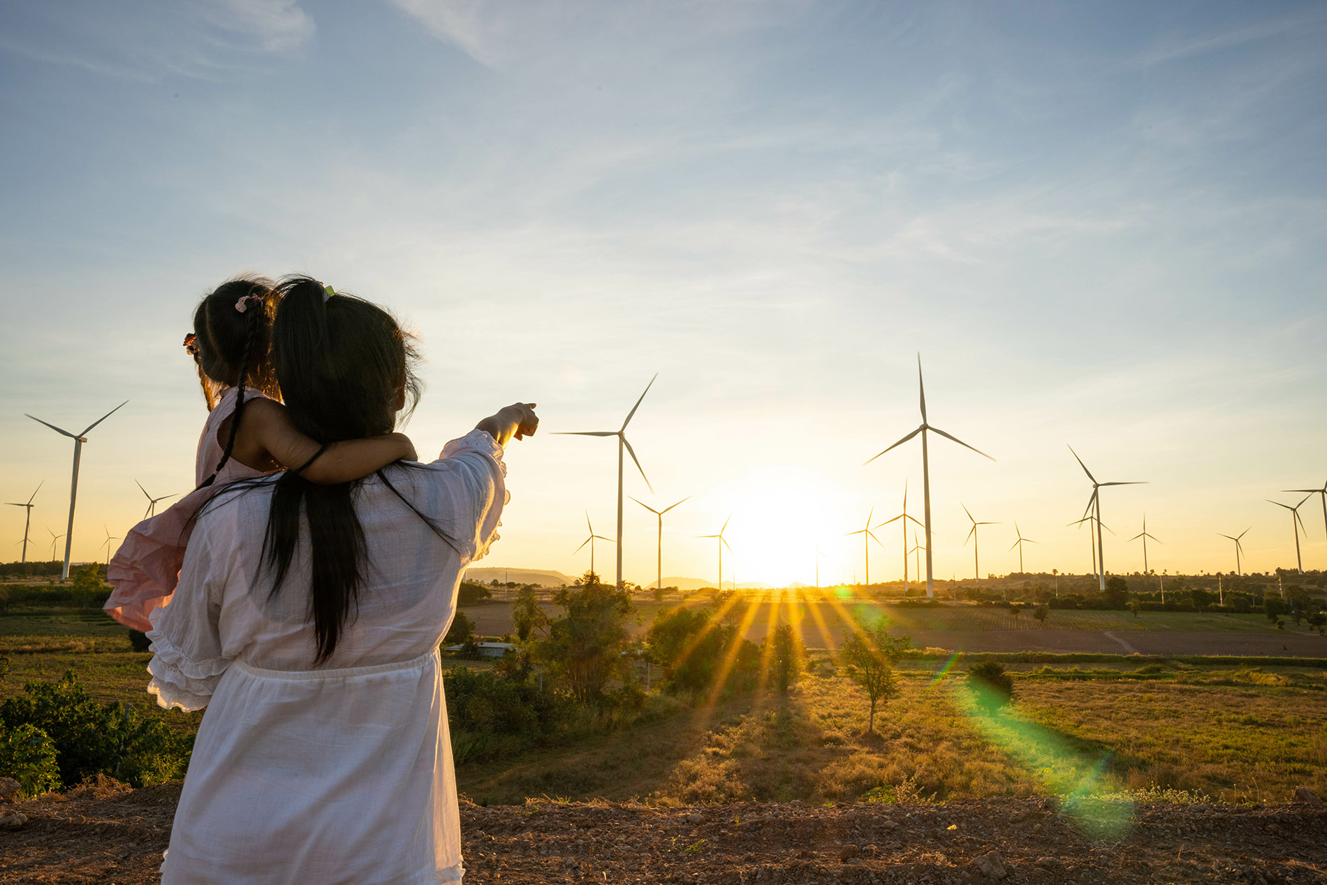 Wind Energy Woman Points at Windmills
