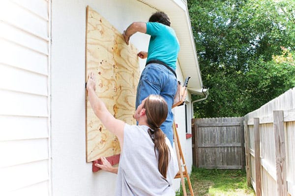 Men Boarding up Window for Hurricane Prep